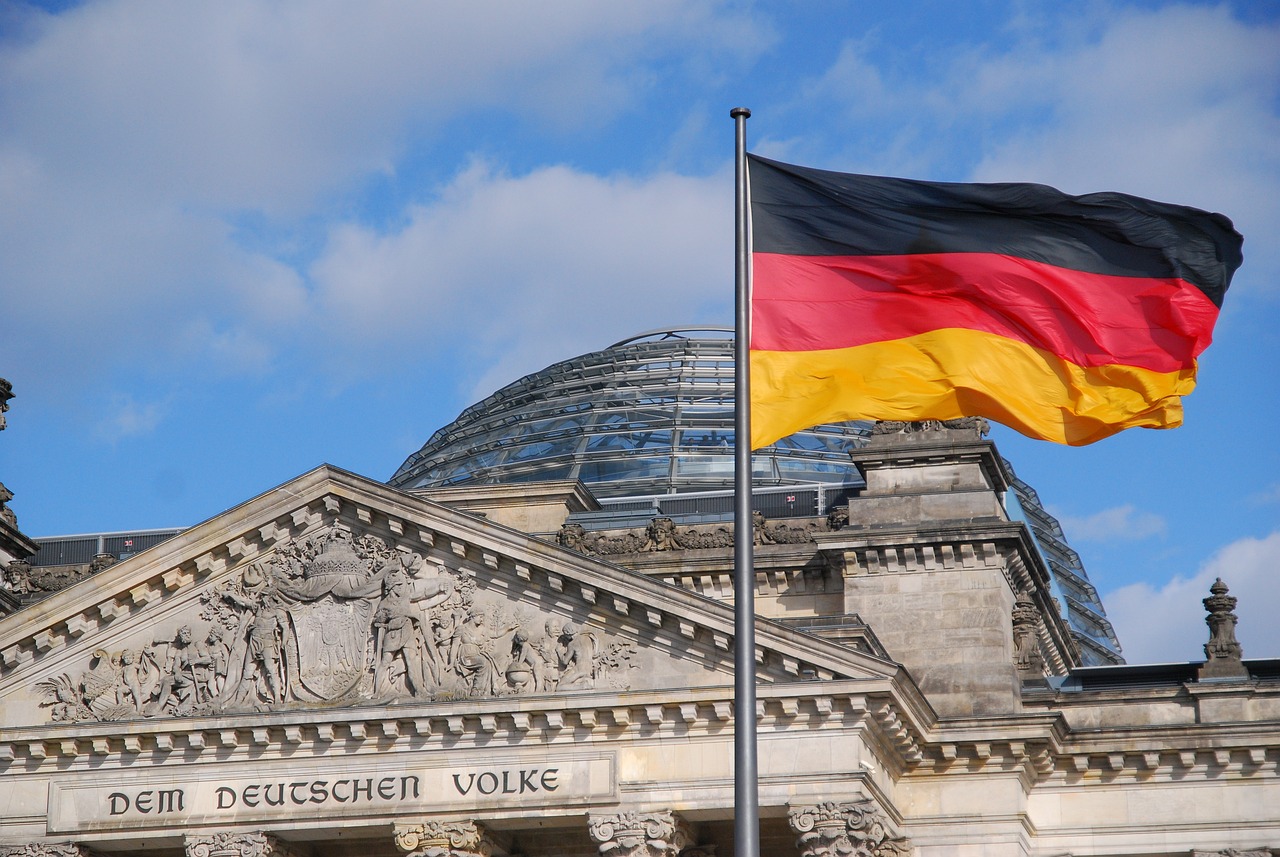 Foto: Schwarz-rot-gelbe Flagge der BRD weht im Wind vor dem Reichstagsgebäude